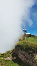 View of communications tower on field against sky