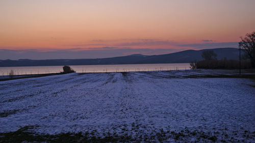 Scenic view of lake against romantic sky at sunset