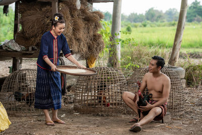 Full length of young couple sitting on land