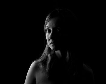 Portrait of woman against black background