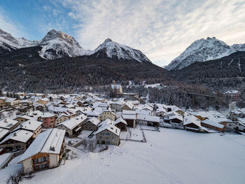 Houses on snow covered mountain against sky