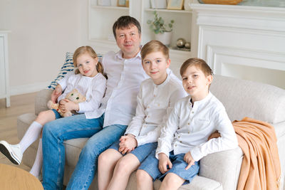 Happy family sitting on sofa at home