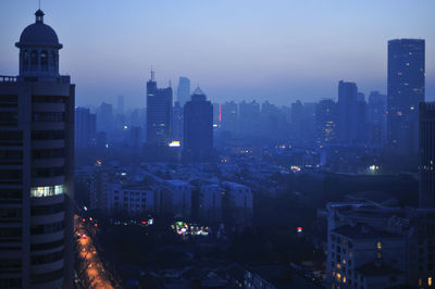 Illuminated cityscape against sky at night