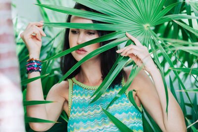 Thoughtful young woman holding plant