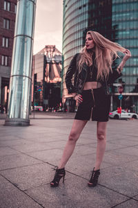 Full length of woman standing on street in city
