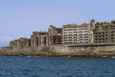 Buildings in city against clear blue sky