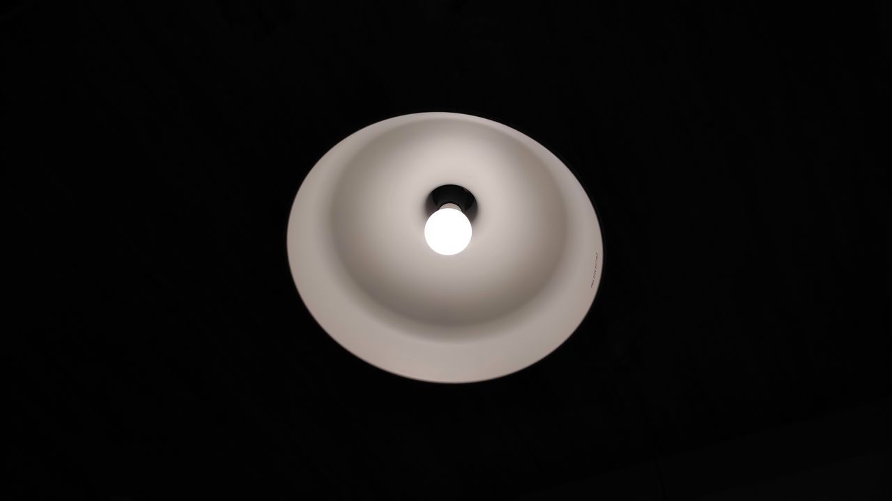 LOW ANGLE VIEW OF ILLUMINATED LIGHT BULB IN DARK