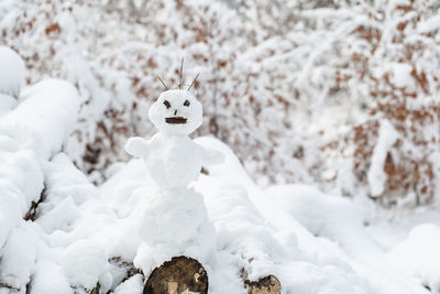 Lonely snowman in snow covered park. winter activities and social distancing concept