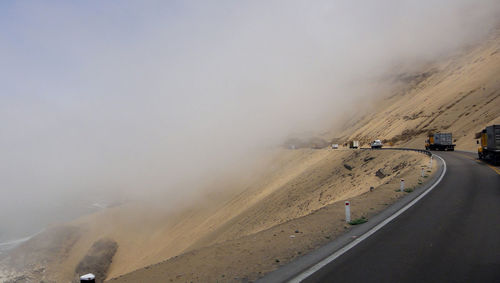 Road by mountain against sky