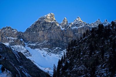 Scenic view of snowcapped mountains against clear blue sky