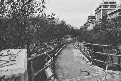 Walkway in city against sky