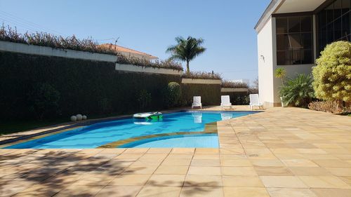 View of swimming pool by building against clear blue sky