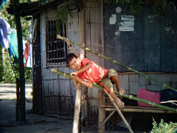 Full length of man holding umbrella in yard against building