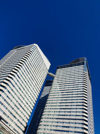 Low angle view of modern buildings against clear blue sky