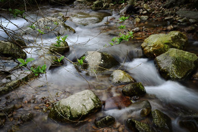 High angle view of stream flowing through rocks