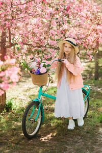 Portrait of smiling young woman with pink flowers in basket