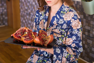 Midsection of woman holding pomegranate