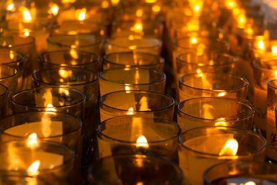 Many candle light in glass burning in the dark