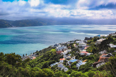 High angle view of townscape by sea against sky