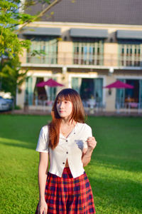 Young woman standing against building