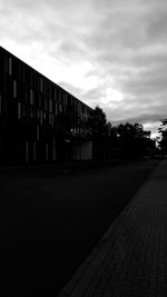 Empty street amidst buildings in city against sky