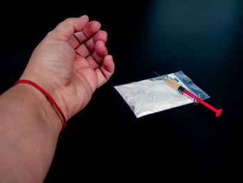 Cropped hand taking drugs at table