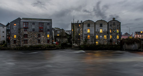 Buildings in front of canal at dusk