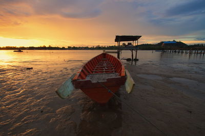 Lifeguard hut on beach against sky during sunset