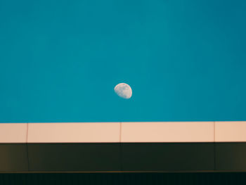 Low angle view of moon against blue sky at night