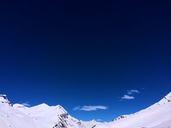 Scenic view of snowcapped mountains against blue sky