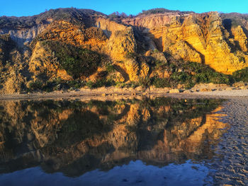 Scenic view of lake by mountain against sky