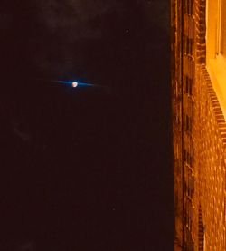 Low angle view of illuminated building against sky at night