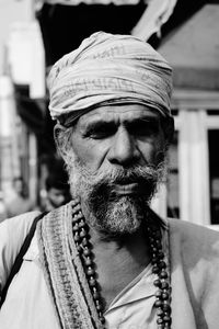 Close-up of bearded senior man wearing turban and mala beads