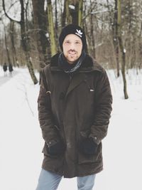 Portrait of young man standing in snow