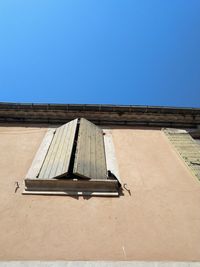 Low angle view of building against clear blue sky