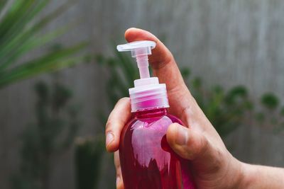 Close-up of hand holding bottle against blurred background