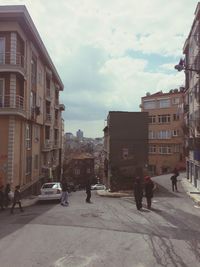 People walking on street amidst buildings in city