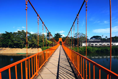 Footbridge over river against sky