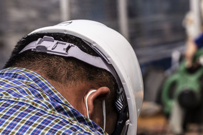 Close-up of manual worker wearing hardhat at construction site