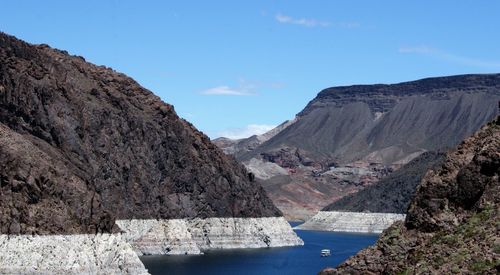 Scenic view of river amidst mountains against sky