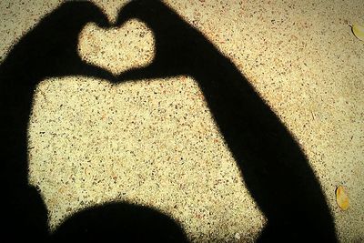 Shadow of heart shape on sand