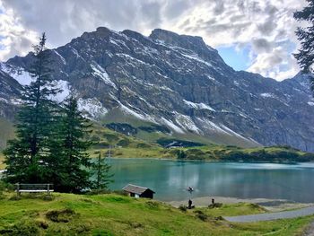 Scenic view of lake by mountains against sky