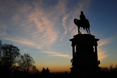 Low angle view of silhouette statue against sky