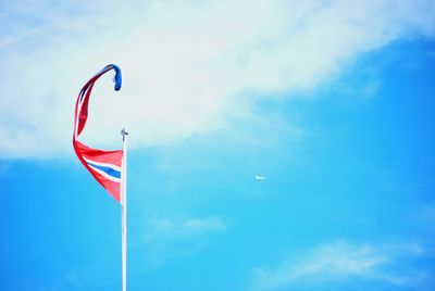 Low angle view of flag against blue sky