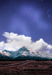 Scenic view of snowcapped mountains against sky at night