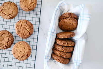 Freshly baked healthy vegan cookie on a cooling rack stand on a table next to milk. view from