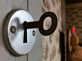 Close-up of rusty metallic key in door lock