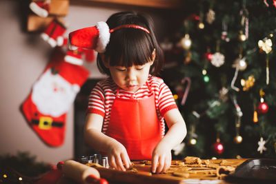 Girl preparing cookie at home during christmas