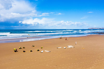 Surfers getting surf lessons at vale figueiras beach in portugal