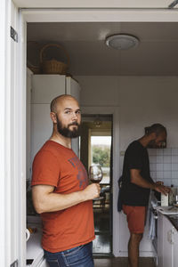 Man holding wineglass in kitchen